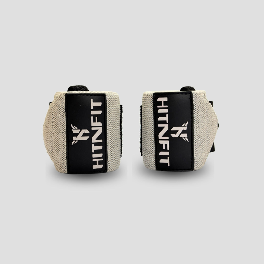 HIT N FIT beige weightlifting wrist wraps with black branded patches and adjustable fastening.