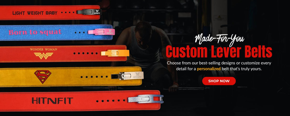 A promotional banner for custom lever belts, showing several stacked belt designs in red, blue, yellow, and orange with logos like Wonder Woman, Superman, and HITNITF. A dark gym scene with a person is visible in the background, alongside text reading 'Made For You Custom Lever Belts' and a 'SHOP NOW' button.